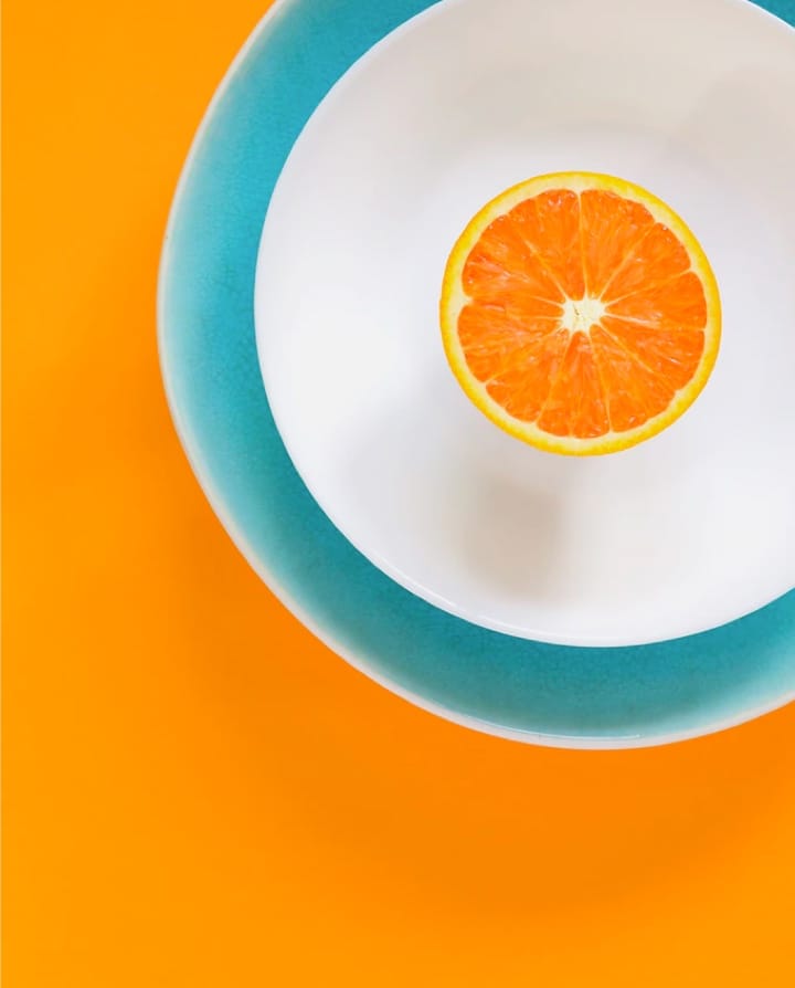 half an orange on white plate
